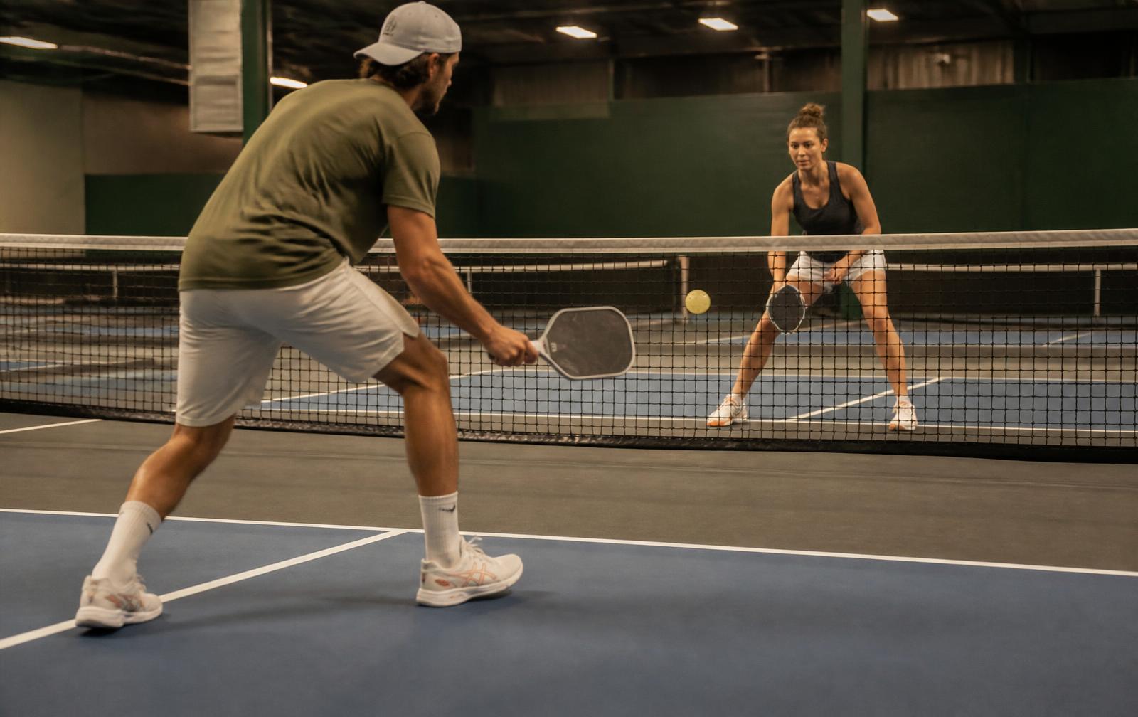 Two players drilling soft shots at the non-volley line